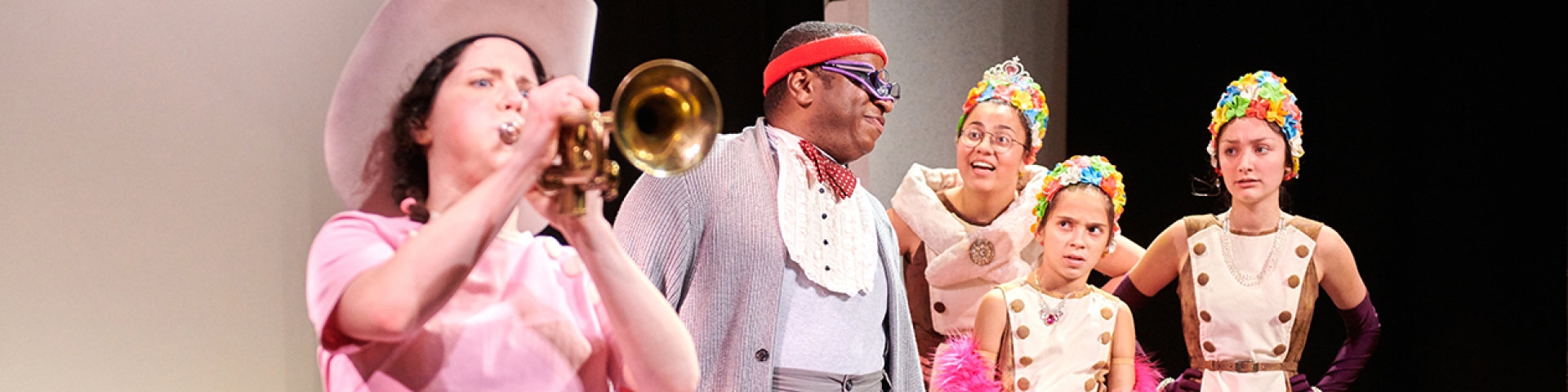 a man playing a trumpet with a woman in the background