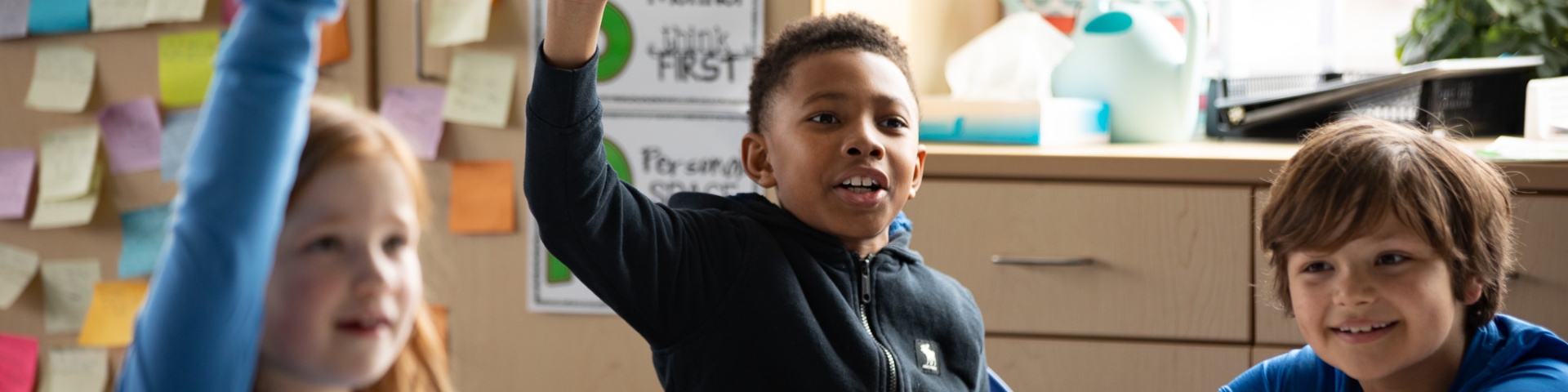 a boy raising his hand